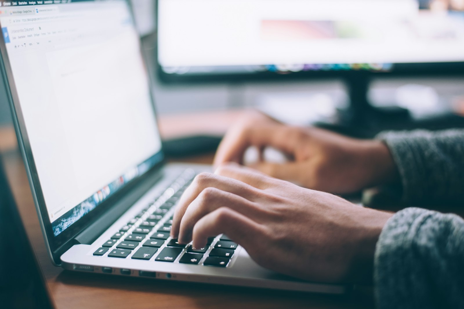 Manos escribiendo código en el teclado de una laptop